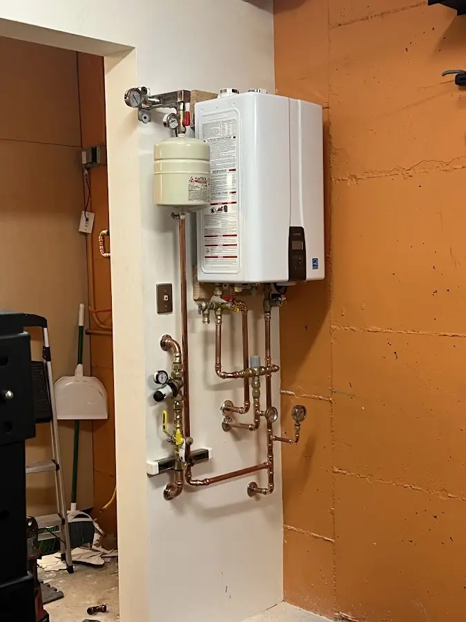 Plumbing technician inspecting water heater connections in South Williamsport